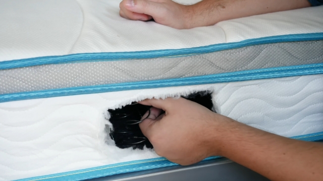 Ruka pokazuje metalne opruge unutar dušeka kroz otvoreni deo navlake