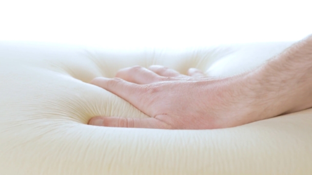 Osoba pritiska mekan dušek kako bi proverila udobnost