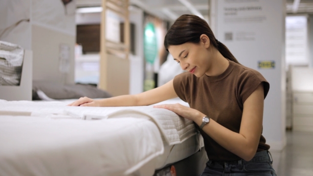 Žena pregleda dušek u salonu nameštaja