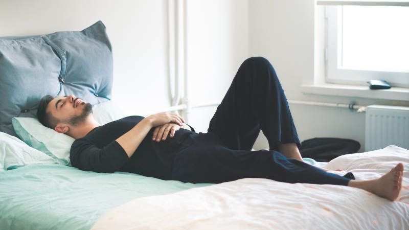 Muškarac spava na leđima u krevetu