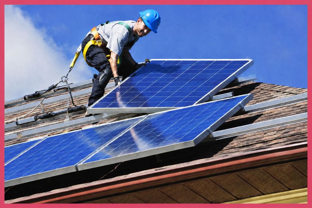 Monter solarnih panela postavlja fotonaponski panel na krov kuće, ilustrujući rast potrebe za stručnjacima za instalaciju i održavanje solarnih sistema