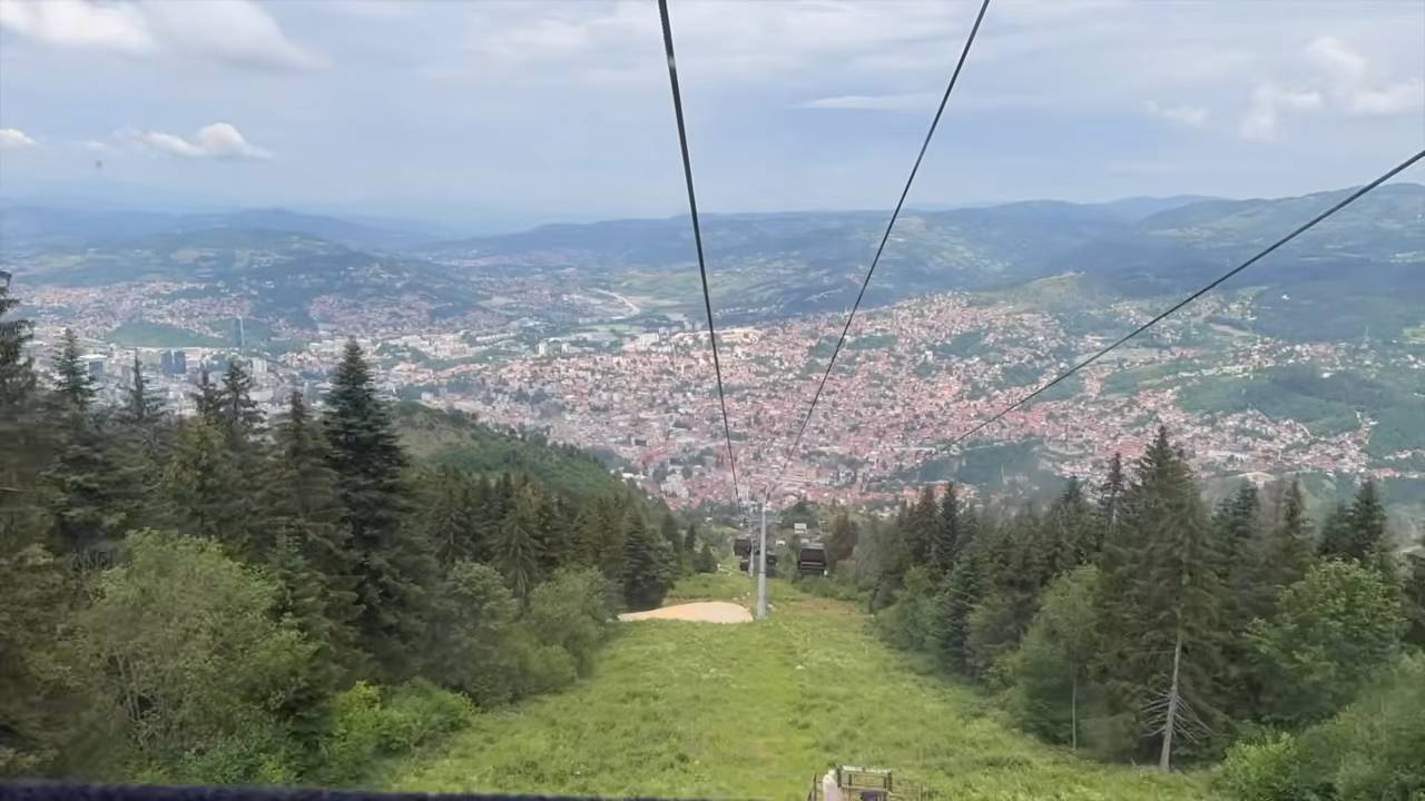 Pogled sa žičare na Sarajevo, šumovite padine Trebevića i okolne planine.